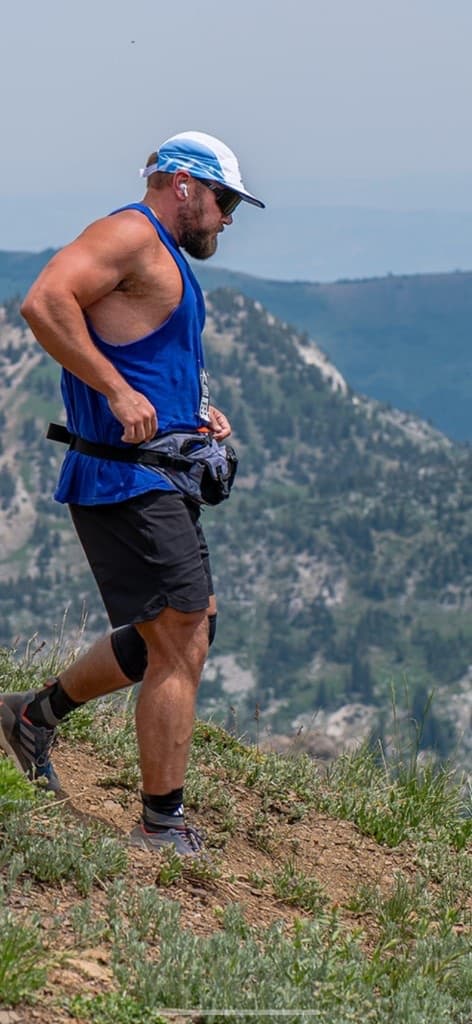 Nick descending a mountain ridge trail above a valley
